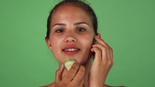 美貌美丽的女人用黄瓜片按摩她的脸视频