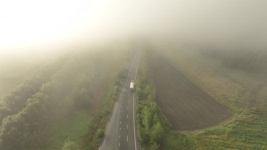晨雾中国道上行驶的汽车视频