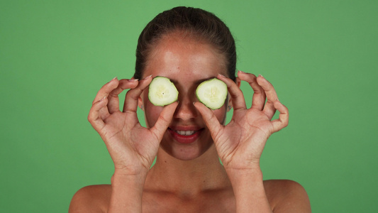 快乐健康的女人用黄瓜片遮住她的眼睛视频