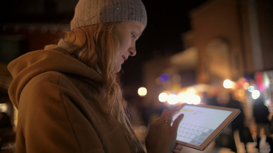 晚上街上使用平板电脑的年轻妇女视频