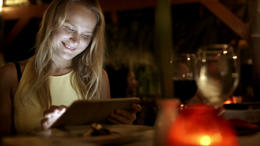 妇女度假时在餐馆里使用平板电脑视频