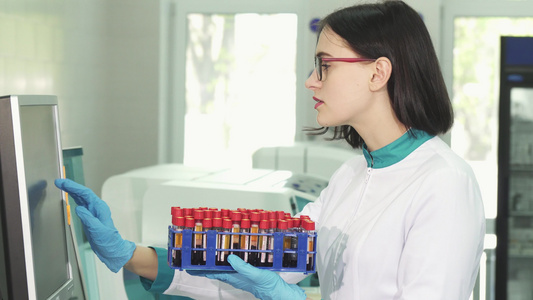 年轻女科学家用血液样本检查测试管的年轻女科学家视频