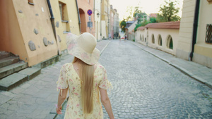 戴着白帽子的漂亮女孩在城里漫步时向着镜头10秒视频