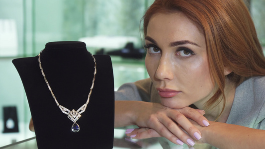 在商店里带着昂贵的钻石项链装扮着悲伤的女人视频