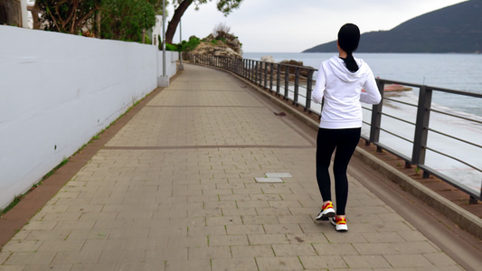 妇女骑着4k视频在海滨上慢跑视频