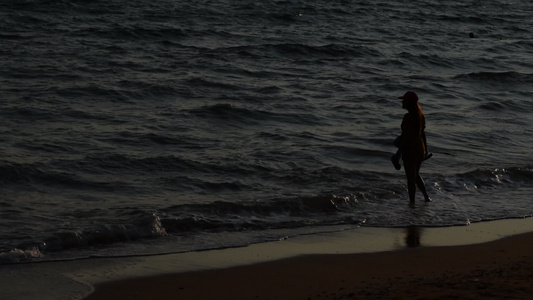 女人在海滩上行走的轮廓视频