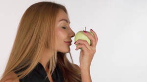 迷人的年轻女子闻着美味的绿苹果笑得开心9秒视频
