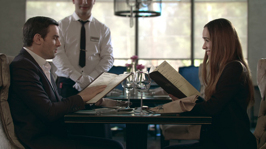 餐厅的一对情侣阅读菜单快乐咖啡馆的商务人士选择食物视频