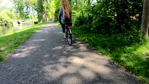后背看女人的金发在风中吹着头发骑着自行车7秒视频