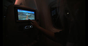 妇女晚上在飞机上使用座椅监视器58秒视频