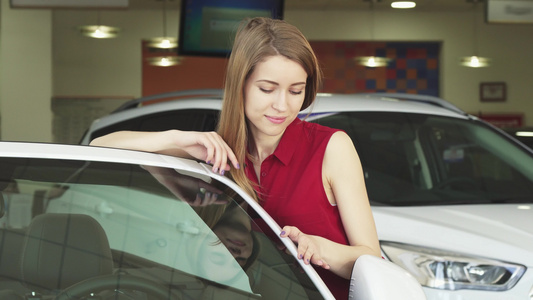 美丽的年轻美女在经销店装上一辆新汽车视频