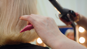 理发师的发型师正在给年长妇女做发型用卷结铁手紧12秒视频