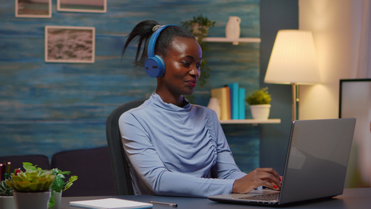 带着耳听音乐的耳机微笑着笑着的黑人设计师妇女视频