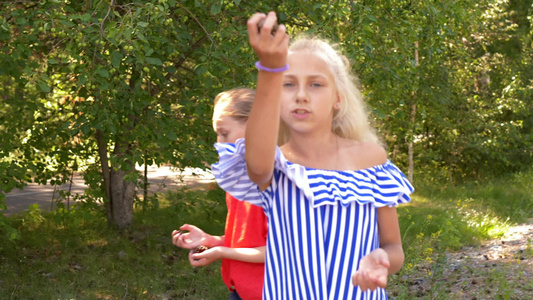 女孩慢慢玩杂耍把松果扔到夏天公园散步视频