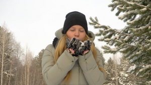 手握雪的女孩在冬季森林中吹起雪来30秒视频