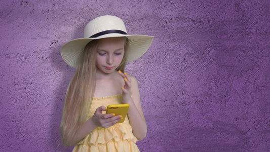 女孩在紫外线背景上装着手机视频