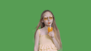 深思熟虑的女孩在假期喝橙汁透明绿色背景笑声21秒视频