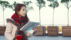 一个小女孩正在研究地图梦幻地盯着远处的视线8秒视频