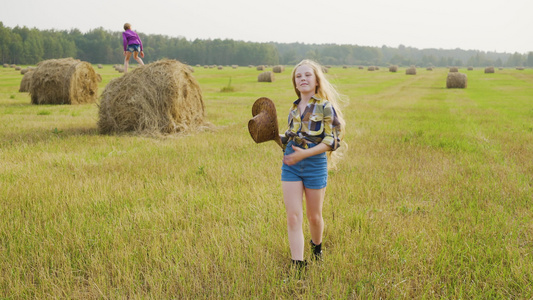 身着格斗衬衫和帽子的女牛仔在农村收获田上行走在乡下视频