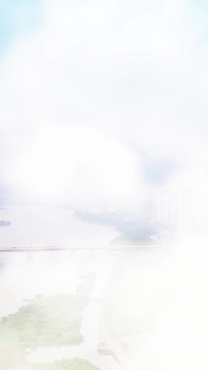 航拍穿过云层看到江景房城市建设15秒视频