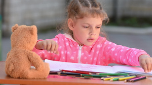五岁女孩在选择想要的彩色铅笔绘画16秒视频