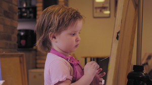 小女孩在工作室的画布上画画微笑着18秒视频