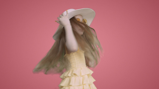 身穿黄色礼服和帽子的女童正在舞动蚂蚁在粉红背景下唱歌视频