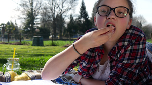 躺在草地上做功课和吃蛋糕的少女26秒视频