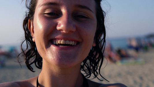 快乐快乐的少女女孩旋转与相机在沙滩上笑着视频