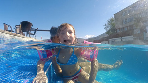 带着臂带的小女孩在游泳池使滑稽舌头向摄影机发出尖锐10秒视频