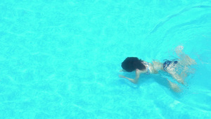 年轻女子在清澈的泳池水中游泳19秒视频