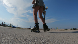 在海边享受阳光和锻炼的裙子里穿着溜冰滑冰鞋的女孩17秒视频