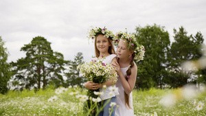 两个女孩戴着鲜花站在盛开的田野上14秒视频