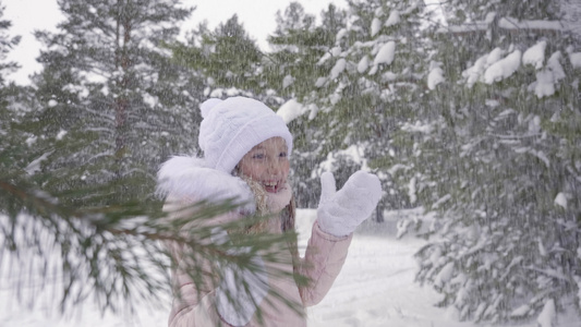 美丽的年轻少女在雪林中欢欣冬季降雪缓慢运动视频