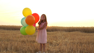 女孩拿着气球在田里行走15秒视频