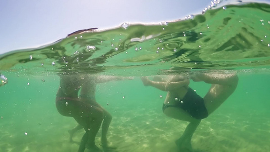 青春少女在绿绿的海水中欢笑和玩耍GOPRO圆顶半水下视频