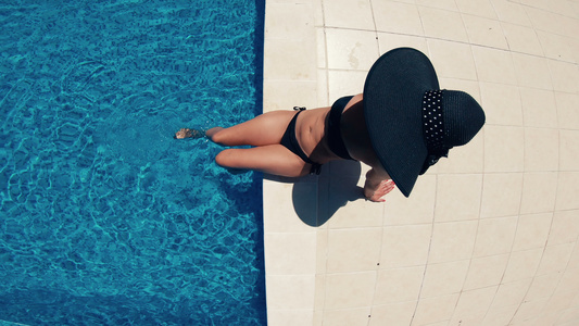 黑帽子和比金尼女人在游泳池顶层风景视频