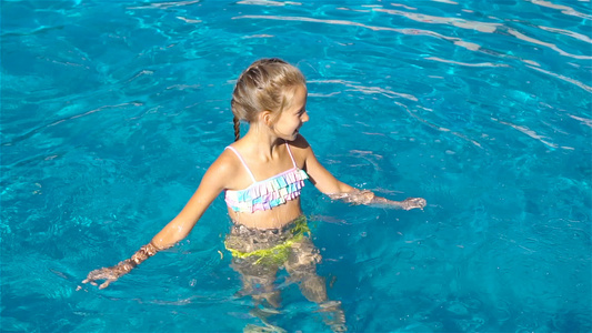在户外游泳池里可爱的小女孩视频