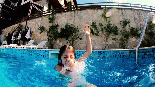 快乐的傻傻小女孩笑在水下游泳池里的相机上视频