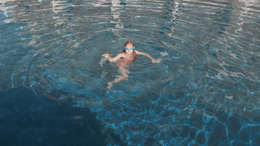 穿着泳装和护目镜的可爱女孩在户外游泳池休息视频