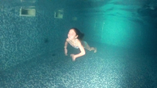 小女孩在室内照明泳池水下游泳视频