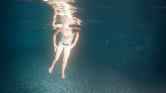 小女孩在暗泳池里翻转水下风景视频