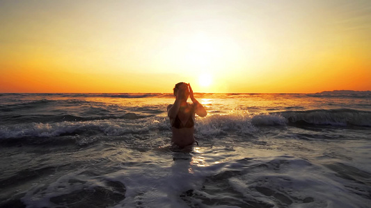 在热带海滩的日落时坐在海水里电影般的稳坐慢动作Y我视频