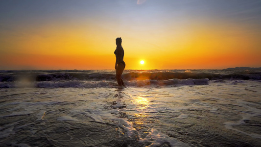 快乐的女人性感完美的身体在日落时在海滩上玩耍和喷水视频