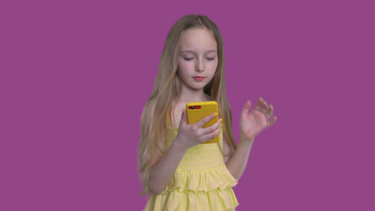 小caucasian女孩看着手机视频