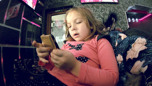 小女孩在室内智能手机上看卡通慢动作19秒视频