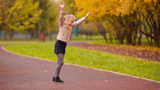活跃的可爱可爱的小女孩玩得开心在美丽的秋天让车轮在视频