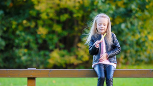在美丽的秋天拿着黄叶的可爱小女孩肖像8秒视频