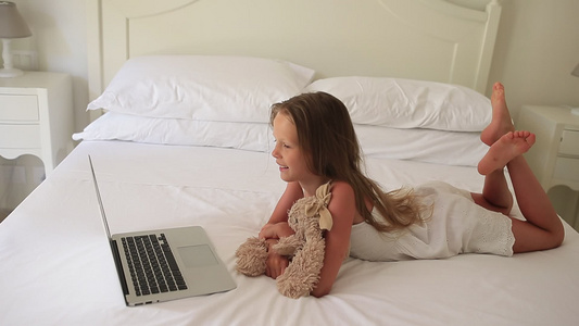 可爱的小女孩在笔记本电脑上做家庭作业视频