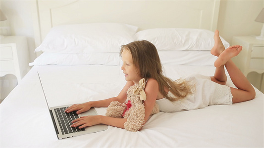 可爱的小女孩在笔记本电脑上做家庭作业视频